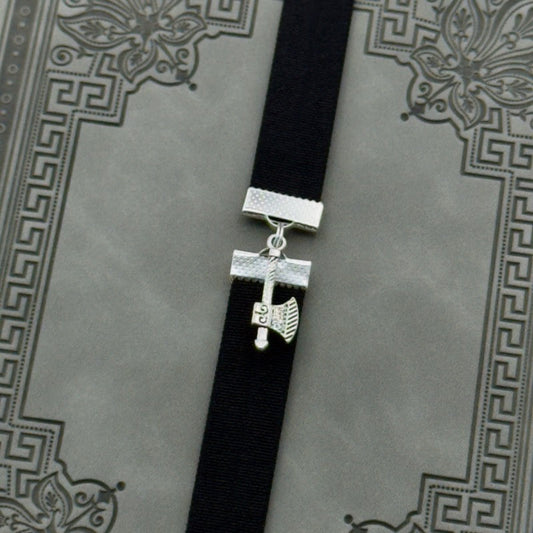A silver axe charm on an elastic Bookband